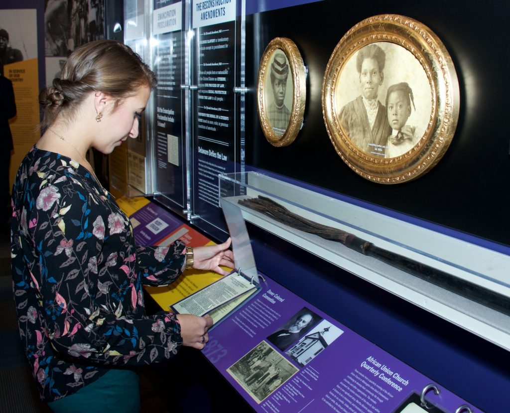 Museum-goer looking at an exhibit. Photo credit: Delaware Historical Society