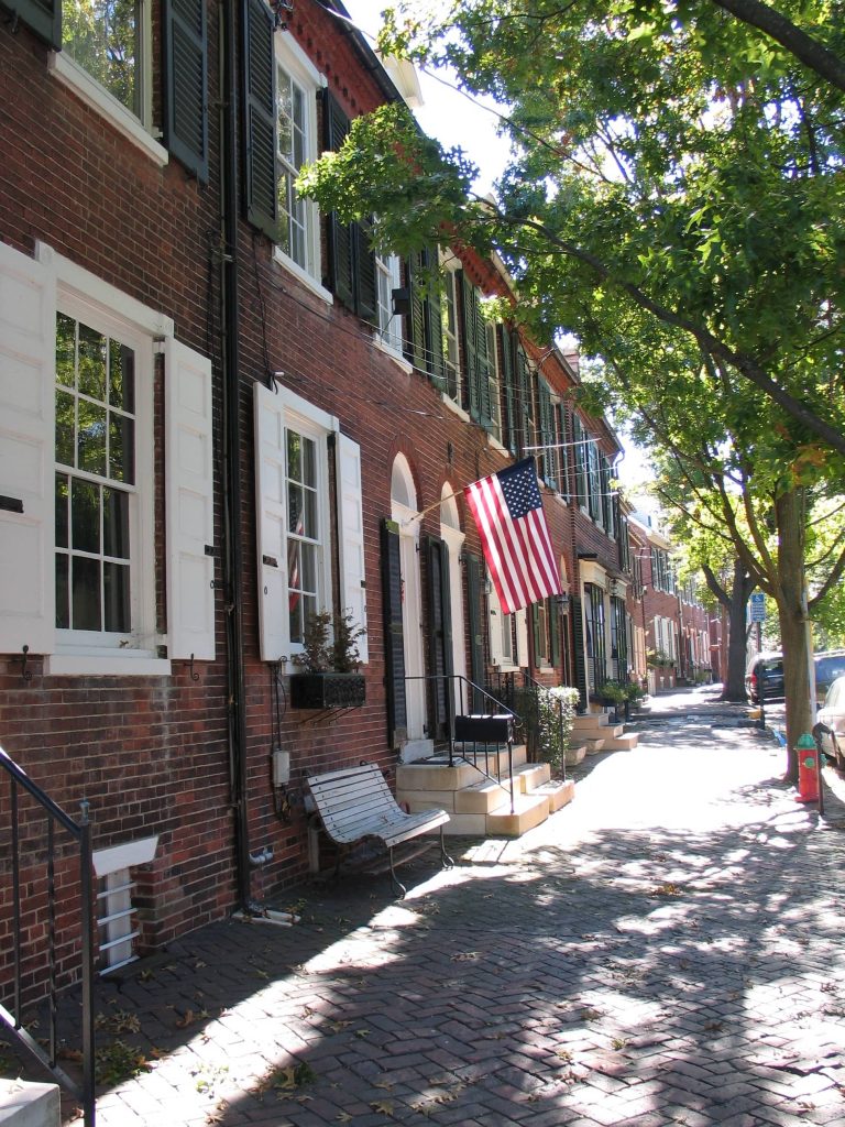 red brick building with American flag flying by the door